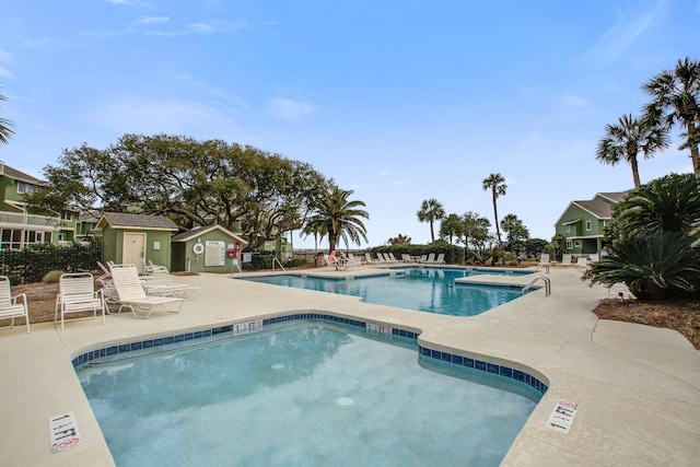 community pool with a patio and fence