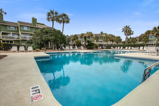 pool featuring a patio area, fence, and a residential view