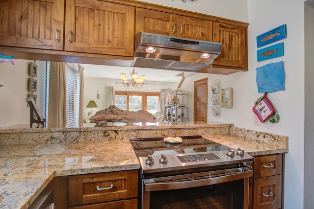 kitchen with light stone counters, brown cabinetry, stainless steel range with electric stovetop, and under cabinet range hood