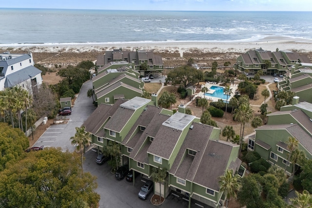 drone / aerial view featuring a view of the beach, a water view, and a residential view