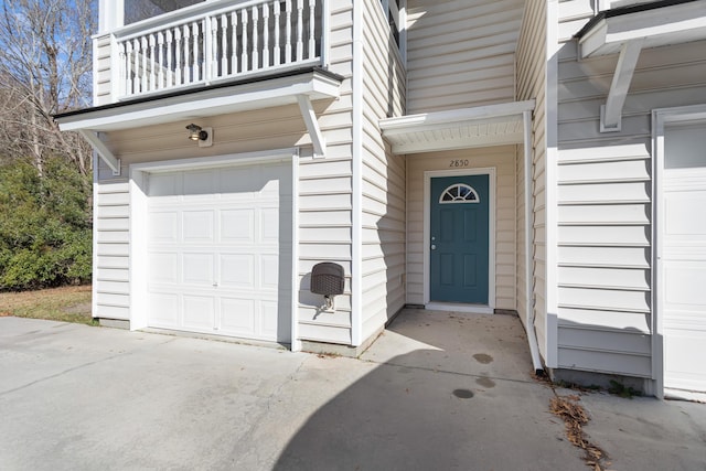 property entrance featuring a garage and a balcony