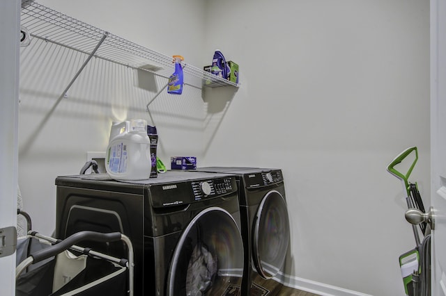 laundry area featuring washer and clothes dryer and dark hardwood / wood-style flooring