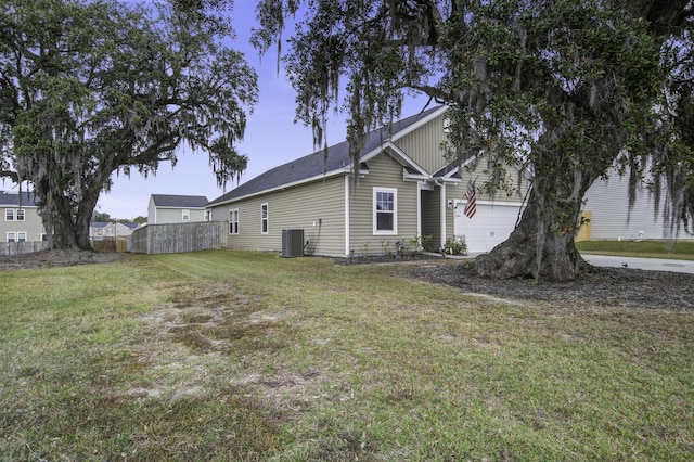 view of side of property with central AC unit, a garage, and a lawn