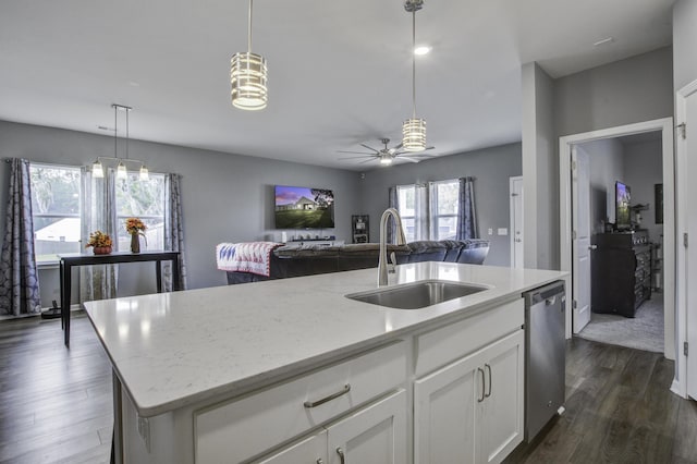 kitchen featuring sink, hanging light fixtures, stainless steel dishwasher, a center island with sink, and white cabinets