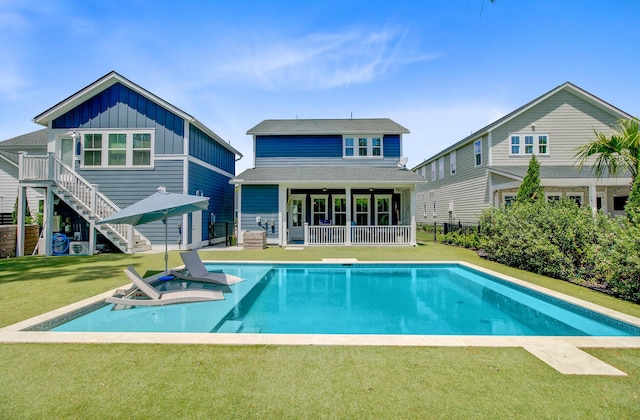 2557 Hatch Dr, Johns Island, SC 29455 - rear view of property featuring board and batten siding, roof with shingles, a lawn, an outdoor pool, and stairway