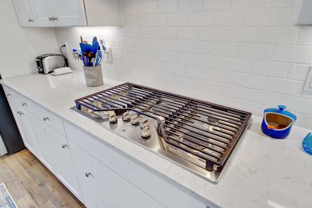 2557 Hatch Dr, Johns Island, SC 29455 - kitchen featuring light stone counters, white cabinets, tasteful backsplash, and stainless steel gas stovetop