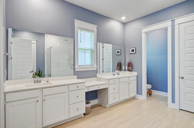 2557 Hatch Dr, Johns Island, SC 29455 - bathroom featuring a tile shower, wood finished floors, vanity, baseboards, and toilet