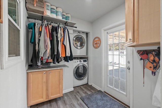 laundry area featuring stacked washer and dryer and light hardwood / wood-style flooring