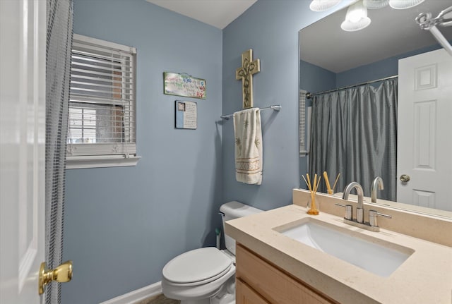 bathroom featuring toilet, vanity, and walk in shower