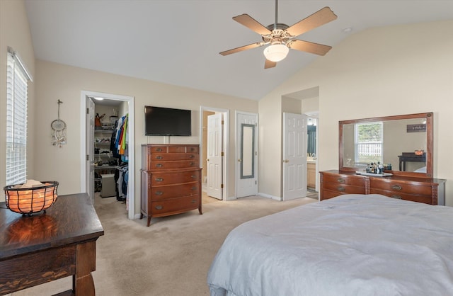 bedroom featuring a spacious closet, lofted ceiling, connected bathroom, a closet, and ceiling fan