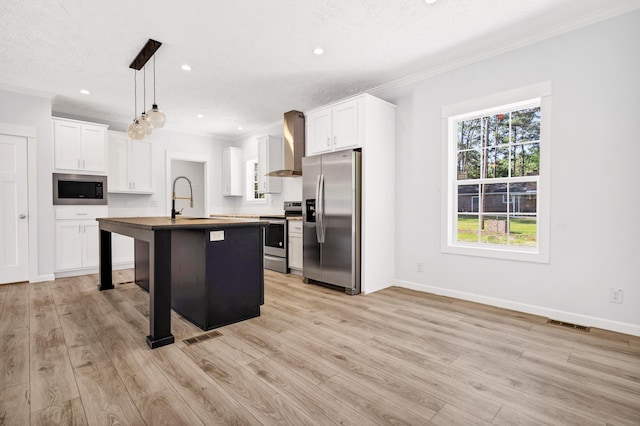 183 Waverly Rd, Walterboro, SC 29488 - kitchen featuring appliances with stainless steel finishes, ornamental molding, light wood-style flooring, and wall chimney exhaust hood