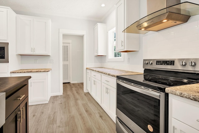 183 Waverly Rd, Walterboro, SC 29488 - kitchen featuring ornamental molding, light wood-style floors, wall chimney range hood, white cabinetry, and stainless steel range with electric cooktop