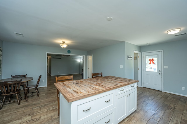 kitchen featuring white cabinetry, hardwood / wood-style flooring, wood counters, and a kitchen island