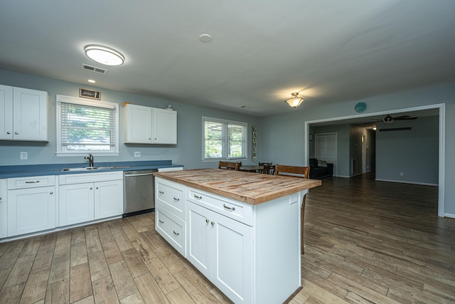 kitchen with plenty of natural light, white cabinetry, and wood counters