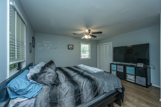 bedroom with wood-type flooring, a closet, and ceiling fan