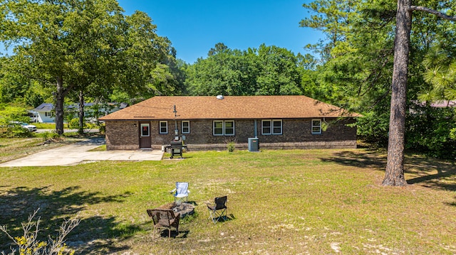 back of house featuring a yard and central AC