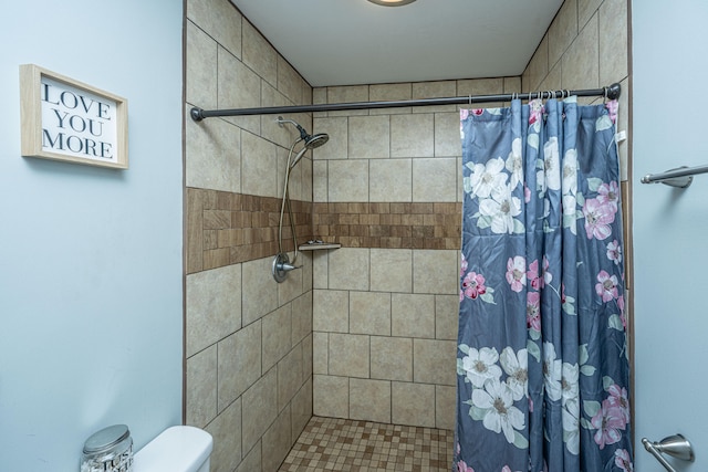 bathroom with a shower with shower curtain and toilet