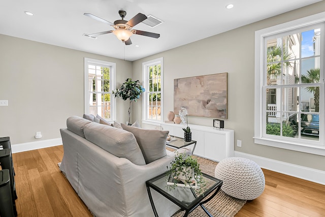 living room with light hardwood / wood-style flooring and ceiling fan