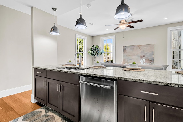 kitchen with light hardwood / wood-style flooring, light stone countertops, sink, ceiling fan, and pendant lighting