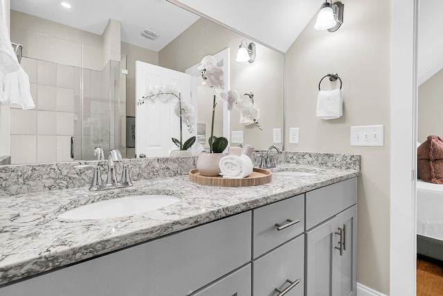 bathroom with vanity, vaulted ceiling, hardwood / wood-style floors, and walk in shower