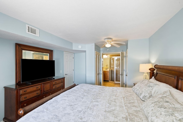 bedroom featuring visible vents, ensuite bath, and a ceiling fan