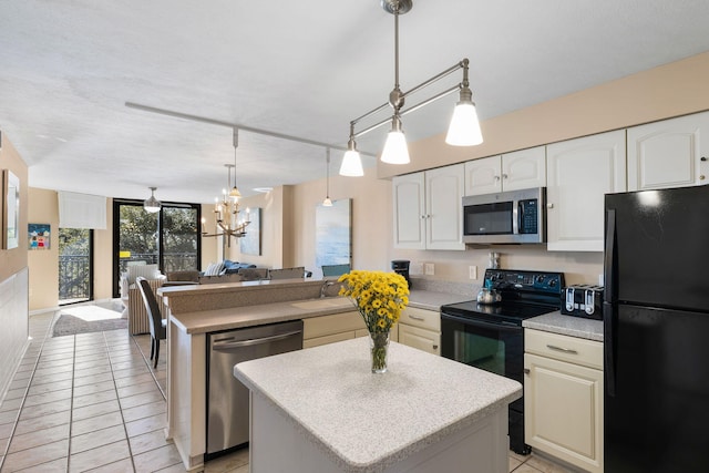 kitchen featuring black appliances, a sink, open floor plan, a center island, and a peninsula