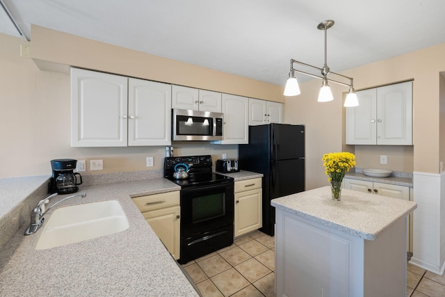 kitchen featuring a kitchen island, light countertops, white cabinets, black appliances, and a sink