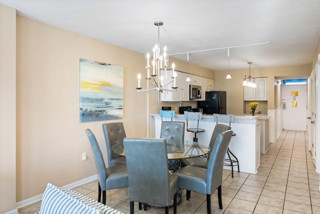 dining room with light tile patterned floors, baseboards, a chandelier, and rail lighting