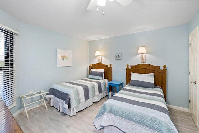 bedroom featuring baseboards, light wood-style floors, and ceiling fan