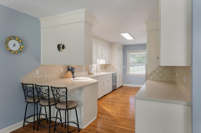 44 S Basilica Ave, Hanahan, SC 29410 - kitchen with dishwasher, a breakfast bar area, white cabinetry, and decorative backsplash