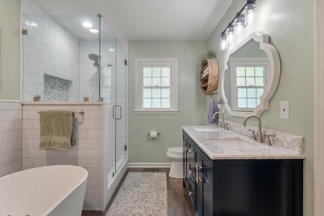 44 S Basilica Ave, Hanahan, SC 29410 - full bathroom featuring wood finished floors, a freestanding tub, double vanity, a shower stall, and toilet