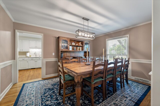 44 S Basilica Ave, Hanahan, SC 29410 - dining area with crown molding, light wood finished floors, and a chandelier