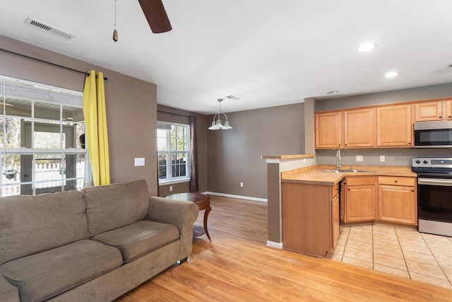 8653 Grassy Oak Trl, North Charleston, SC 29420 - kitchen with appliances with stainless steel finishes, light countertops, a sink, visible vents, and open floor plan