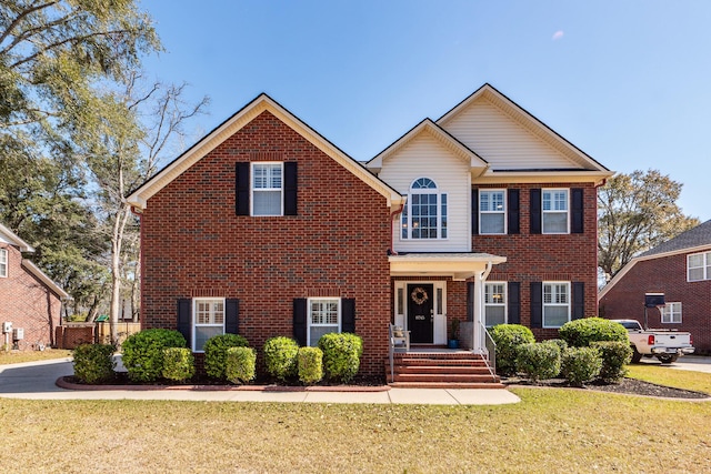 view of front of home with brick siding and a front yard