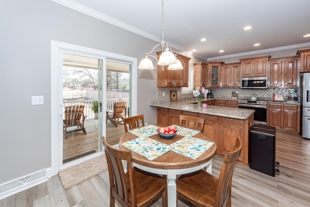 dining area featuring recessed lighting, light wood-style floors, and ornamental molding