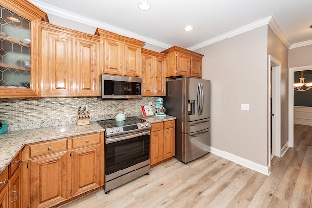 kitchen featuring decorative backsplash, light stone countertops, appliances with stainless steel finishes, and light wood-style flooring