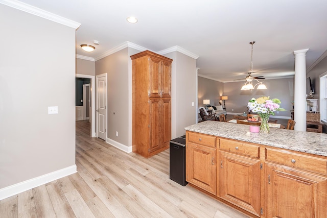 kitchen featuring light stone counters, decorative columns, ceiling fan, ornamental molding, and light wood-style floors