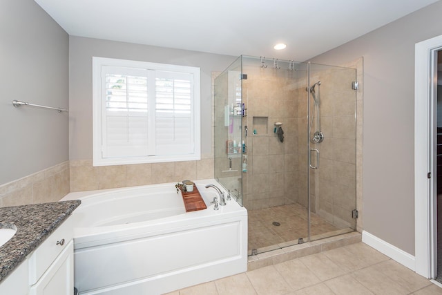 full bath featuring vanity, a shower stall, a garden tub, and tile patterned flooring