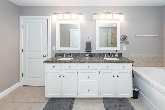 bathroom featuring tile patterned flooring, a bath, and a sink