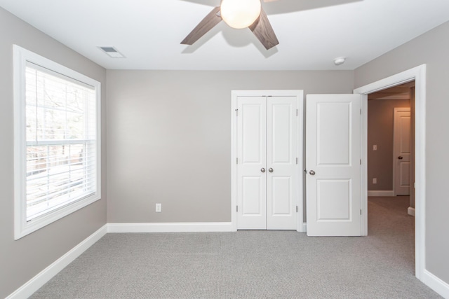 unfurnished bedroom featuring visible vents, carpet floors, and baseboards