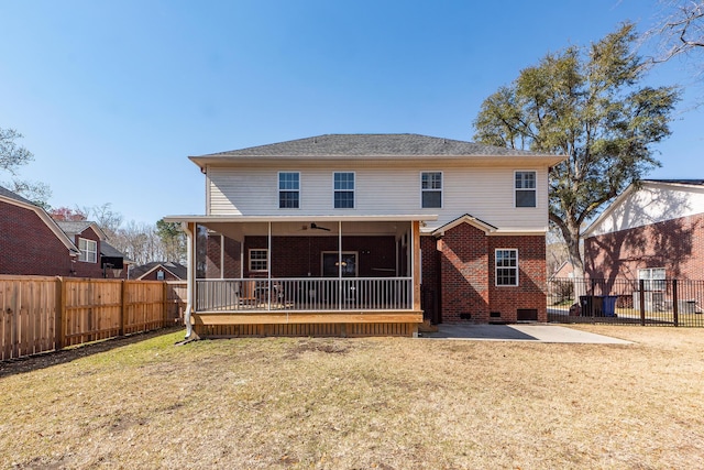 rear view of house with a yard, brick siding, and a fenced backyard