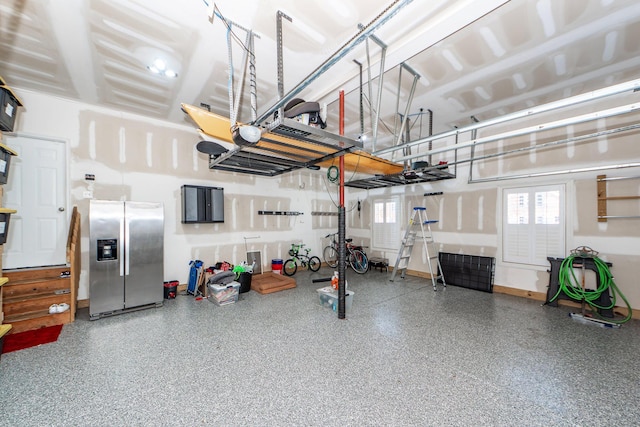 garage featuring french doors, baseboards, and stainless steel refrigerator with ice dispenser