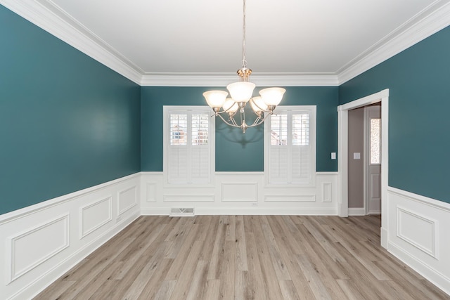 unfurnished room featuring a wainscoted wall, an inviting chandelier, light wood-style floors, and visible vents