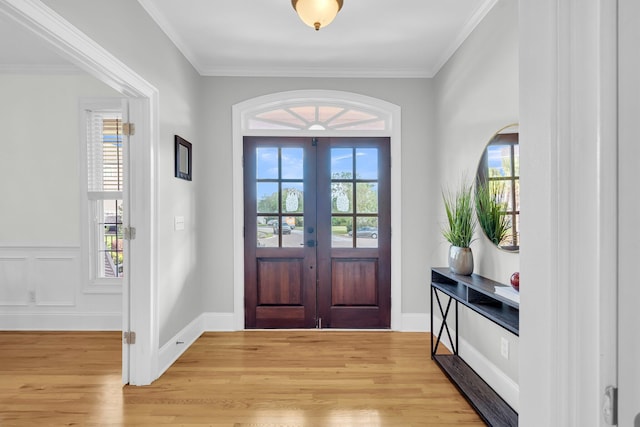 entryway with healthy amount of natural light, light wood-style flooring, french doors, ornamental molding, and baseboards