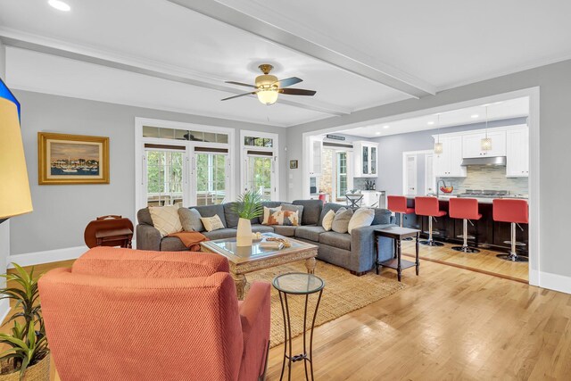 living room with light wood-style floors, beamed ceiling, recessed lighting, baseboards, and ceiling fan