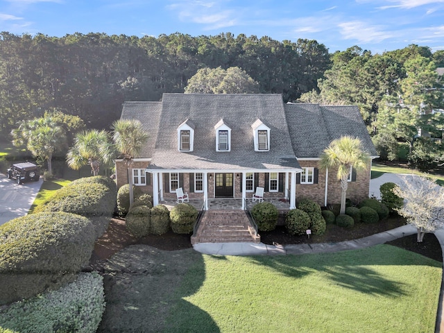 new england style home with a porch, a front yard, and stairway