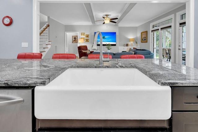 kitchen featuring a ceiling fan, a sink, open floor plan, stone counters, and dishwasher