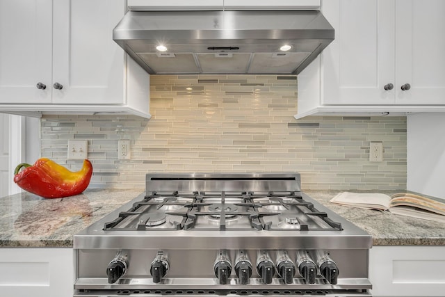 kitchen featuring range hood, stainless steel range with gas stovetop, white cabinets, and tasteful backsplash