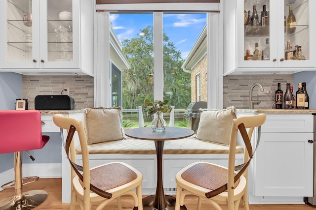 dining room with bar and light wood-style floors