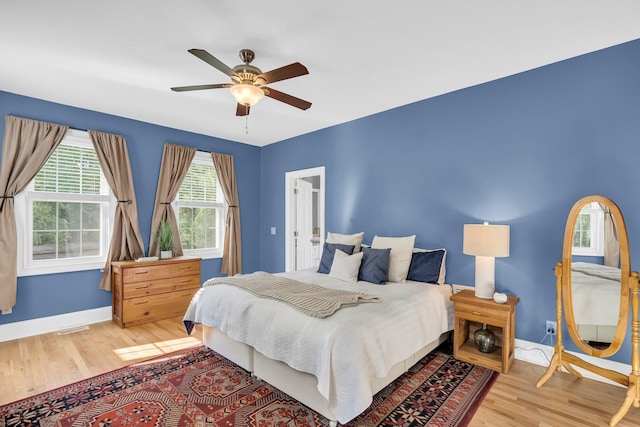 bedroom featuring light wood-style floors, baseboards, and ceiling fan